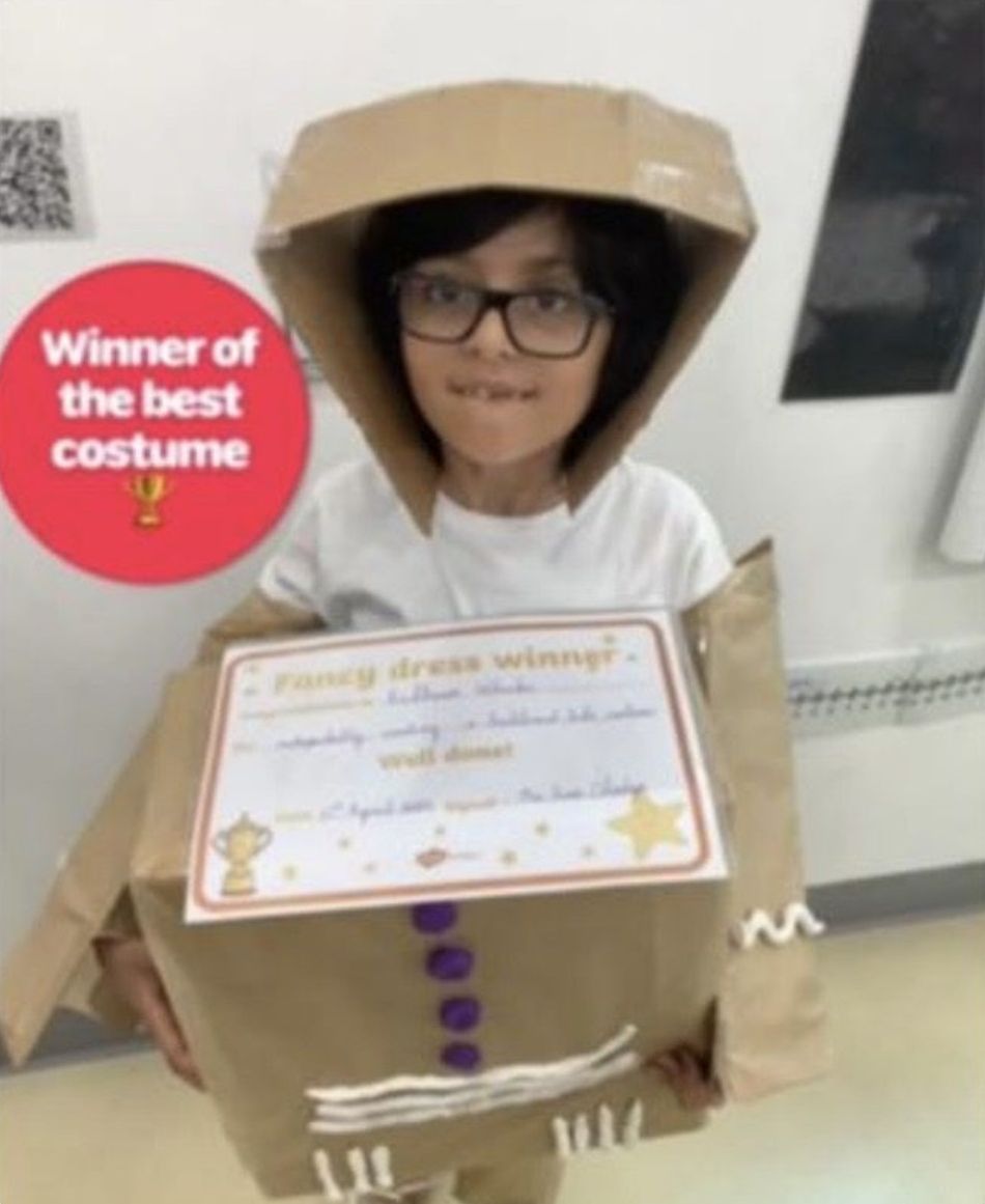 Ridhaan holding his best costume award in his cardboard costume